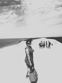 Full length of shirtless man on beach against sky