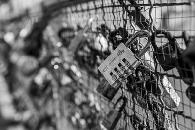 Close-up of padlocks hanging on fence