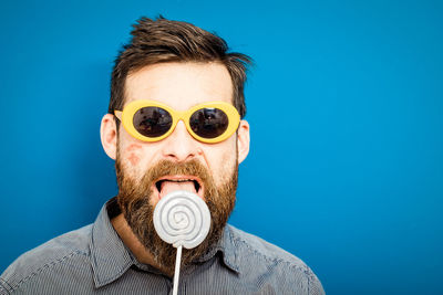 Portrait of young man against blue background