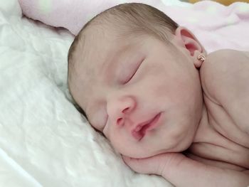 Close-up of baby sleeping on bed