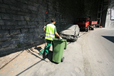 Rear view of man working on street