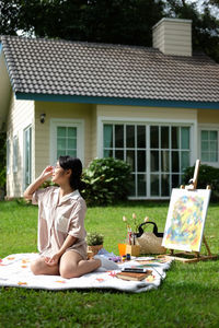 Side view of woman sitting on field