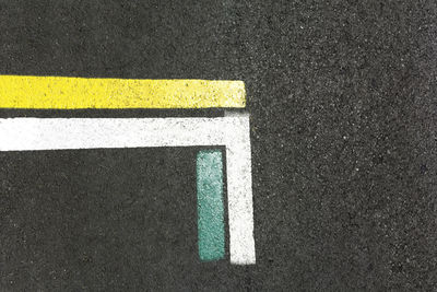 High angle view of yellow arrow symbol on road