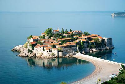 High angle view of buildings by sea against clear sky