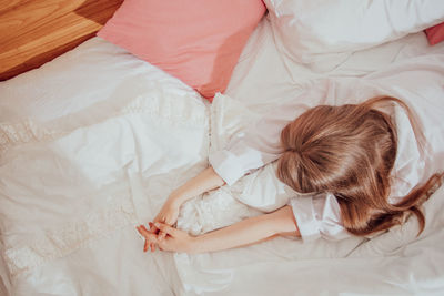 High angle view of woman lying on bed at home