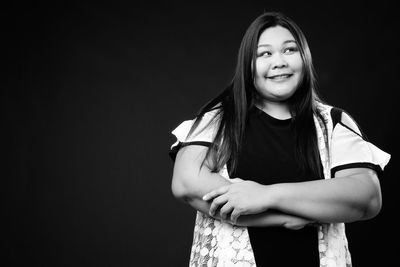 Portrait of smiling girl against black background