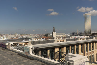 Bridge by buildings against sky in city