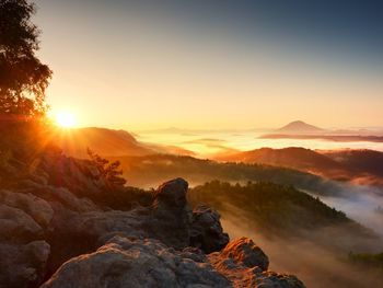 Beautiful autumnal landscape with mountain view, morning foggy valley within sunrise. 