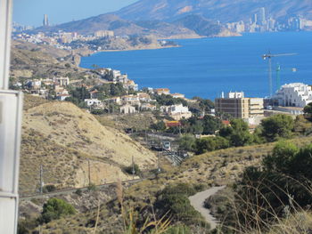 High angle view of buildings by sea against sky