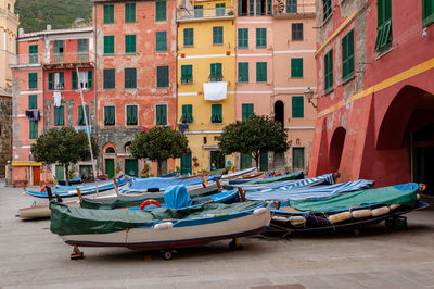 Boats moored in canal by buildings in city