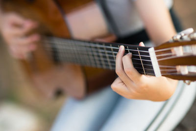 Midsection of man playing guitar