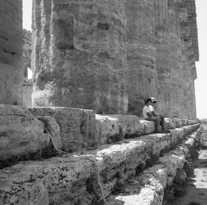 Man leaning on wall of building