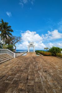 View of footpath against cloudy sky