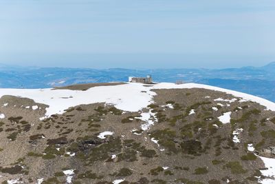 Scenic view of sea and snowcapped mountains against sky
