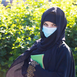 Portrait of woman standing against plants