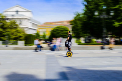 Man riding bicycle on road in city