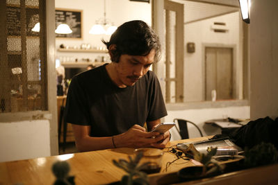 Man holding camera on table at home