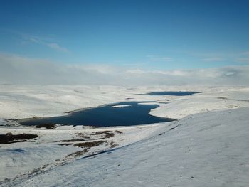 Scenic view of snowcapped landscape against blue sky