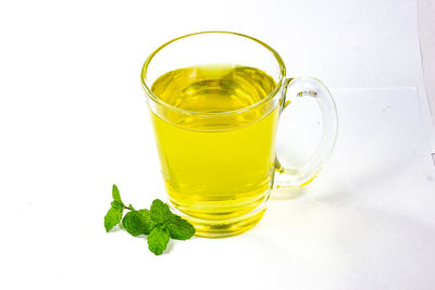 Glass of drink on table against white background