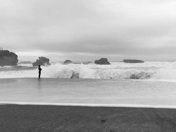 Man standing on beach against sky