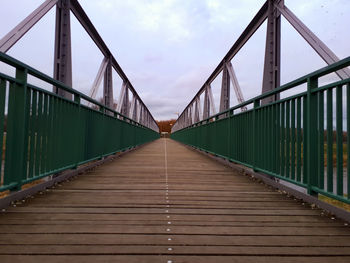 Empty footbridge against sky