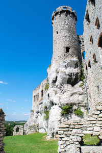 Low angle view of castle tower against blue sky