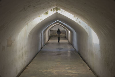 Rear view of man standing in tunnel