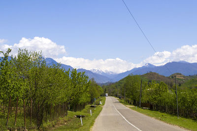 Empty highway and road in georgia during sunlight, blue sky and trees