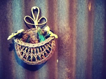 Close-up of wicker basket on table against wall