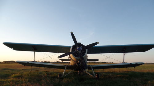 Airplane flying over runway against clear blue sky