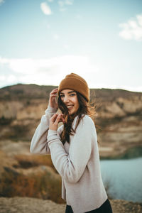 Young woman using phone while standing on camera