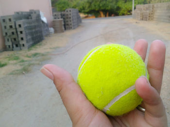 Close-up of hand holding tennis ball