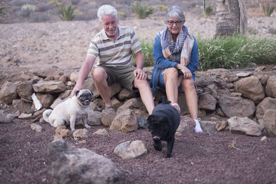 Senior couple with dogs on rocks