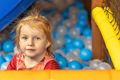 Portrait of a little toddler girl with red hair in a ballroom.