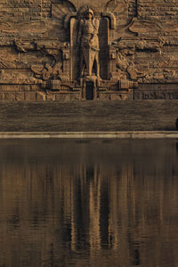 Reflection of statue in lake