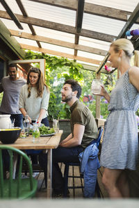 Happy friends enjoying summer party at log cabin