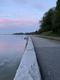 Road by lake against sky