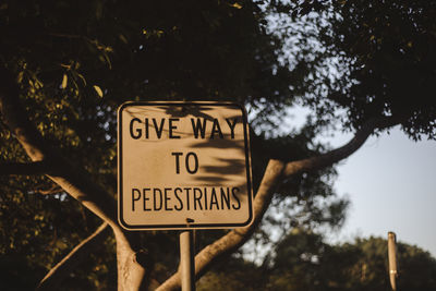 Low angle view of road sign against trees