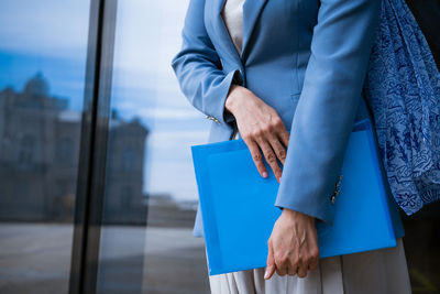 Business woman with folder in hand near office building