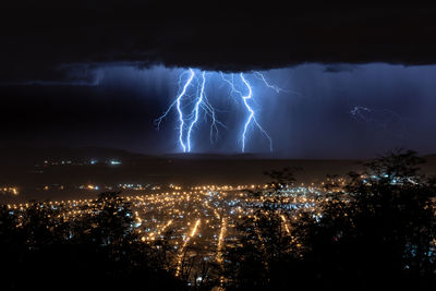 Aerial view of illuminated cityscape against sky at night