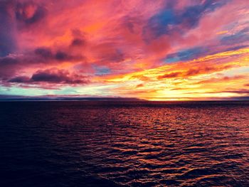 Scenic view of sea against dramatic sky during sunset