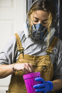 Female resin artist mixing with respirator mask