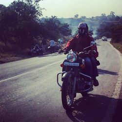 People riding motorcycle on road