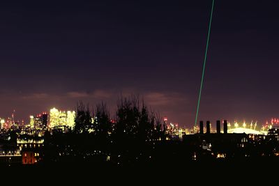 Illuminated cityscape against sky at night