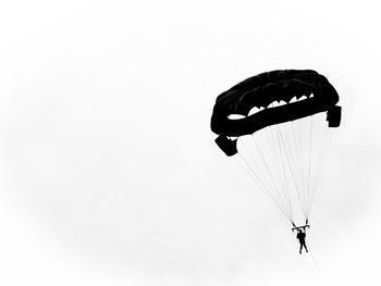 Low angle view of person paragliding against clear sky