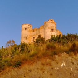 Low angle view of castle against clear blue sky