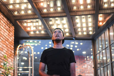 Low angle view of man standing in illuminated building