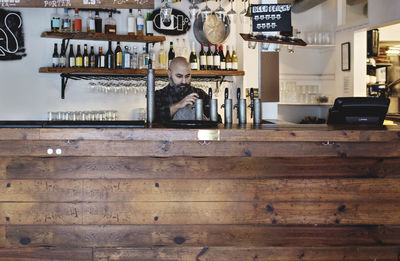 Bartender working while standing at bar counter