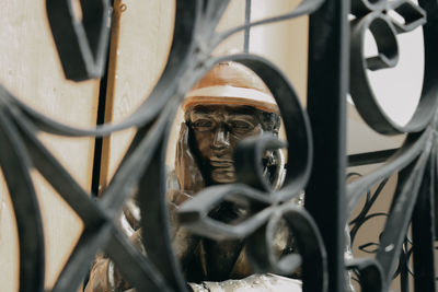 Sculpture seen through metal fence