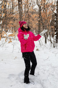 Full length of woman standing on snow covered field